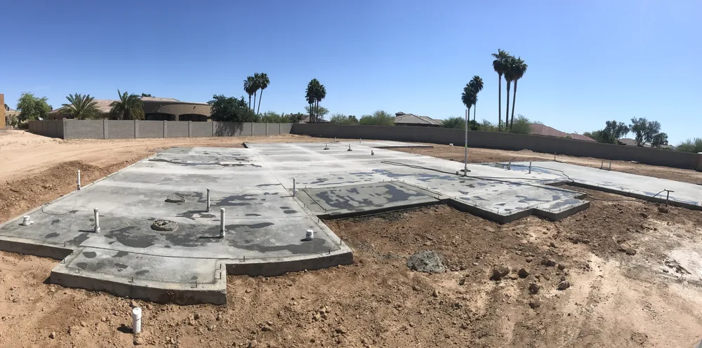 A broad concrete foundation laid out on a desert building site